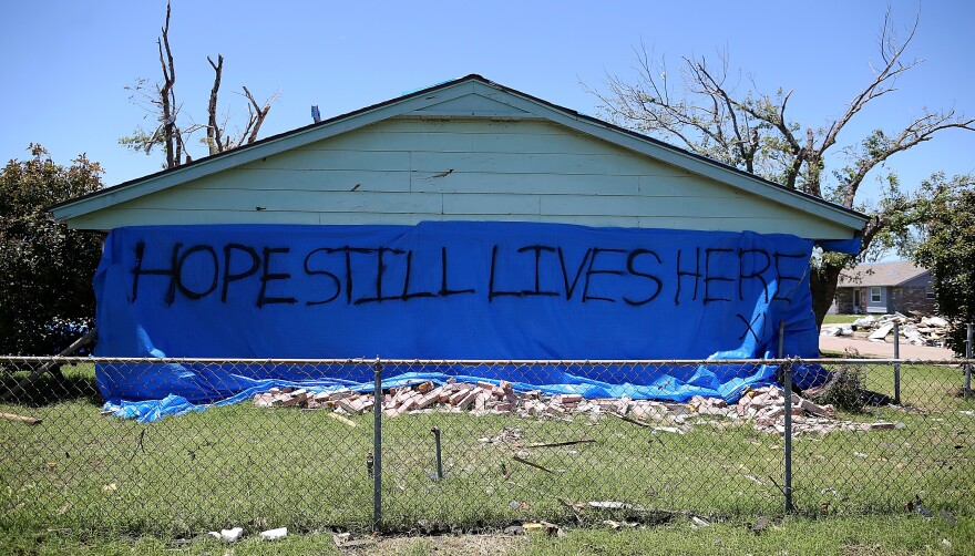 A sign proclaiming "Hope Still Lives Here" is posted on the side of a damaged home in Moore, Okla.