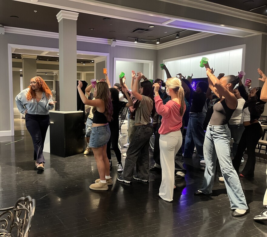 Student Kenya Thomas, left, rehearses with the cast of "Factotum: The Groom & Glow Lounge."