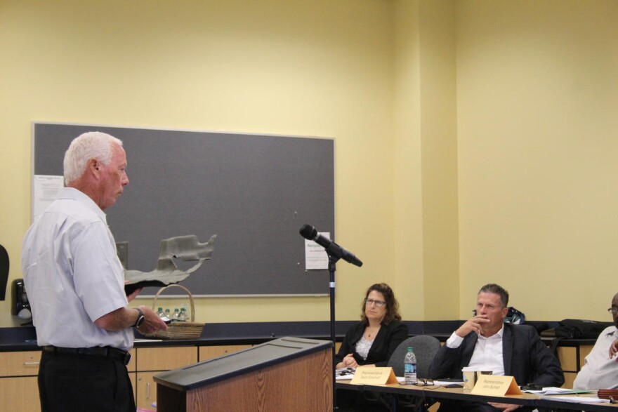 Elkhart-based FlexForm Technologies CEO Gregg Baumbaugh shows the study committee one of the car parts his company makes using hemp.