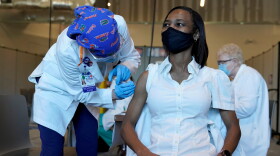 Registered nurse La Tanya Forbes, right, is inoculated with the Pfizer-BioNTech COVID-19 vaccine by RN Cheryl Birmingham, left, at Memorial Healthcare System, Monday, Dec. 14, 2020, in Miramar, Fla.