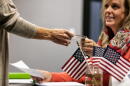 Person handing voter ID to election official. 