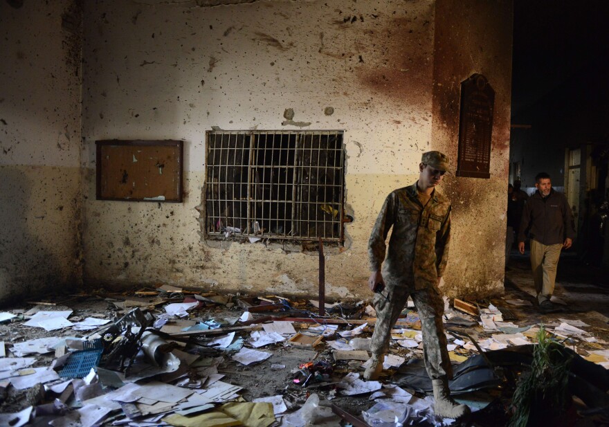 A Pakistani soldier walks amid the debris in an army-run school Wednesday, a day after Taliban militants attacked the school in Peshawar.