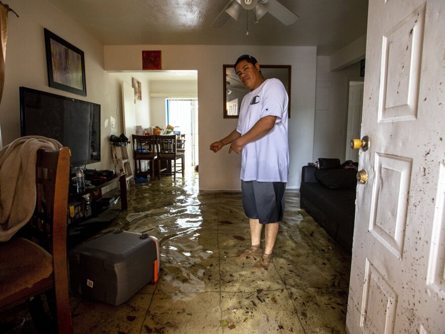 Olban Tremeneo Lagos, 42, points to the water inside his apartment in the Little Havana neighborhood of Miami, on Saturday.