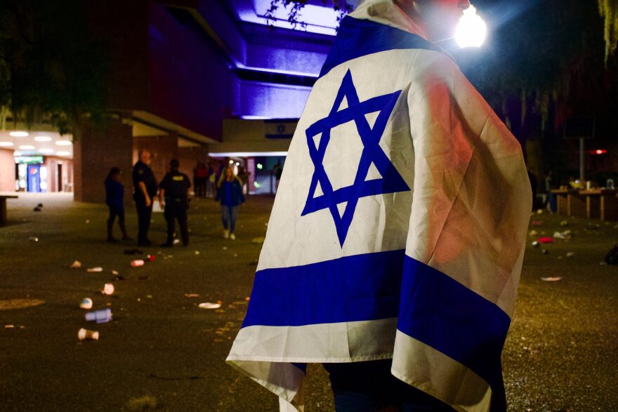 A student stands in an emptied Turlington Plaza wrapped in an Israeli flag.