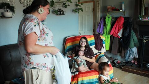 Misty Pipe (left) delivers a care package for one of the women she recently supported through pregnancy, Britney WolfVoice. Pipe offers free doula care outside of her post office job because Lame Deer — her hometown on the Northern Cheyenne Indian Reservation in Montana — is about 100 miles from the closest hospital that delivers babies.