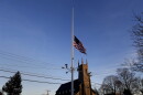 A flag is seen at half-staff along Main Street in Newtown, Conn., on Friday after a mass shooting that left at least 28 dead, including the suspected gunman.