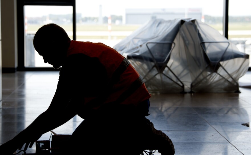 A carpenter works in the unfinished departure hall of the airport on Sept. 11.