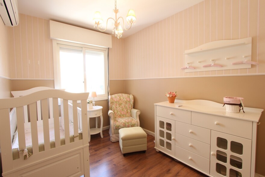 A bedroom with a crib.