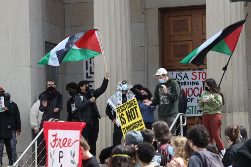 Protesters at the University of Rochester gather outside and on the steps of Wallis Hall on Wednesday, May 1, 2024, where some have begun a sit-in inside the building that houses UR administrative offices.