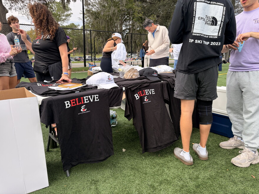 Members of Eli Silverman’s family sell T-shirts at the Nose Bowl on Sunday Oct.18, 2026. (Madison Middleton/WUFT News)