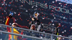 Chip Ganassi Racing driver Alex Palou, left, Andretti Global driver Kyle Kirkwood, center, and Andretti Global driver Will Power raise their trophies after the Java House Grand Prix of Arlington on March 15.