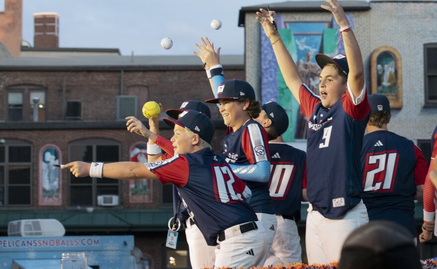 Members of the Mid-Atlantic team react to seeing fans from their float in the Little League World Series parade.