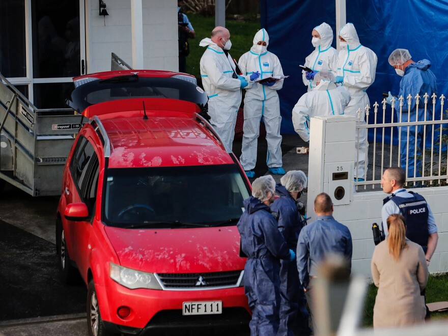 New Zealand police investigators work at a scene in Auckland on Aug. 11, 2022, after bodies were discovered in suitcases.