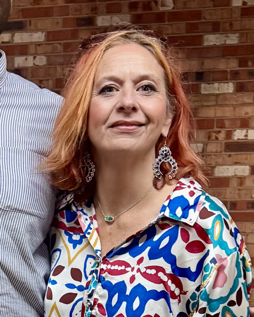 Kerri Poeling Padilla in a colorful shirt, posing for a photo. 