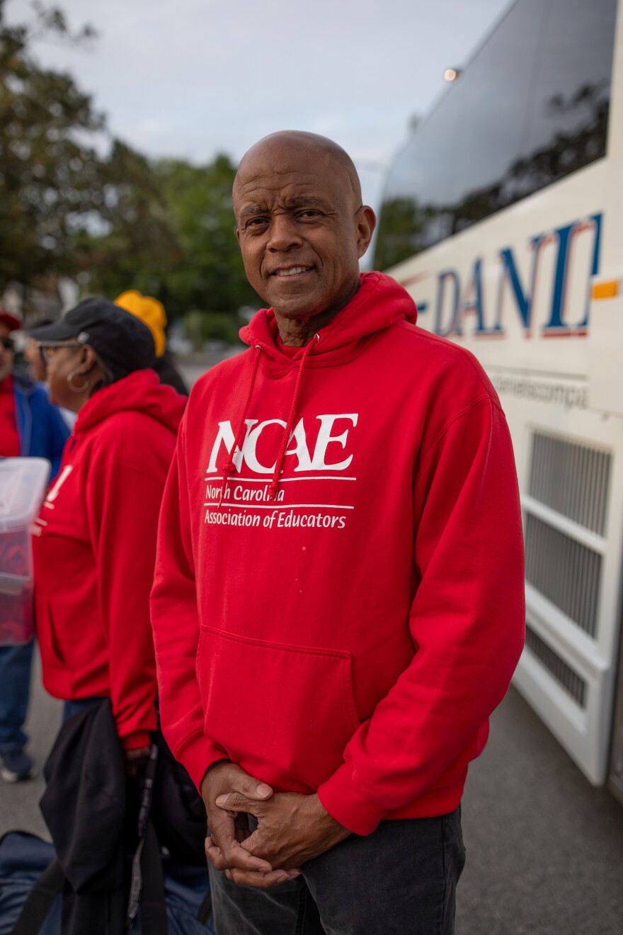 Daniel Webb, who is a member of the New Hanover County Association of Educators, prepares to board a bus to Raleigh for the 'Kids Over Corporations' rally organized by the North Carolina Association of Educators on May 1, 2026. North Carolina is currently ranked 46th in the country for teacher pay.