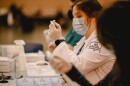 A vaccinator prepares a dose of a COVID-19 vaccine at the Ernest N. Morial Convention Center. March 4, 2020.
