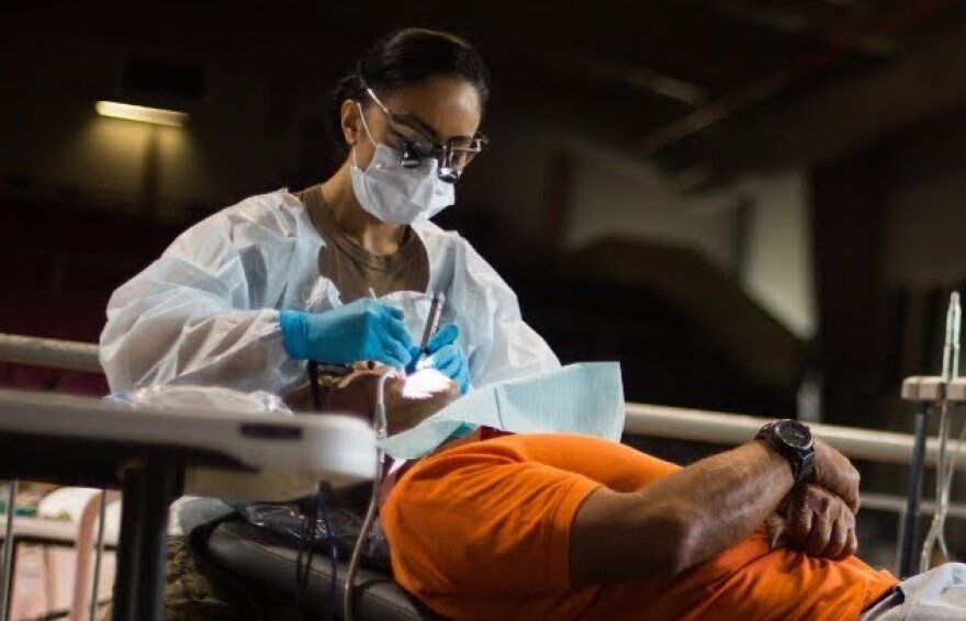  An Army member provides dental work at a community clinic. Such services will be available in Ava, Eminence and Houston for a week, free of charge.