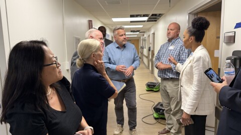 Eight people standing in a hallway