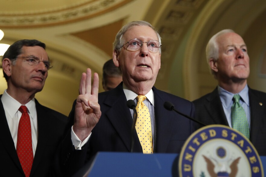 Senate Majority Leader Mitch McConnell is flanked by Sen. John Barrasso, R-Wyo., (left) and Senate Majority Whip John Cornyn of Texas (right).  They are three of the 13 senators in the health care working group.
