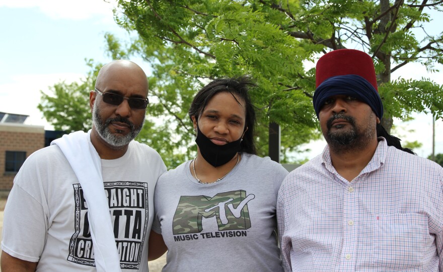 three people standing in front of a tree