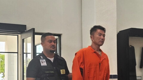Longgui “Andy” Yan, 39, arrives in CNMI Superior Court Wednesday for a bail hearing escorted by Corrections officers.