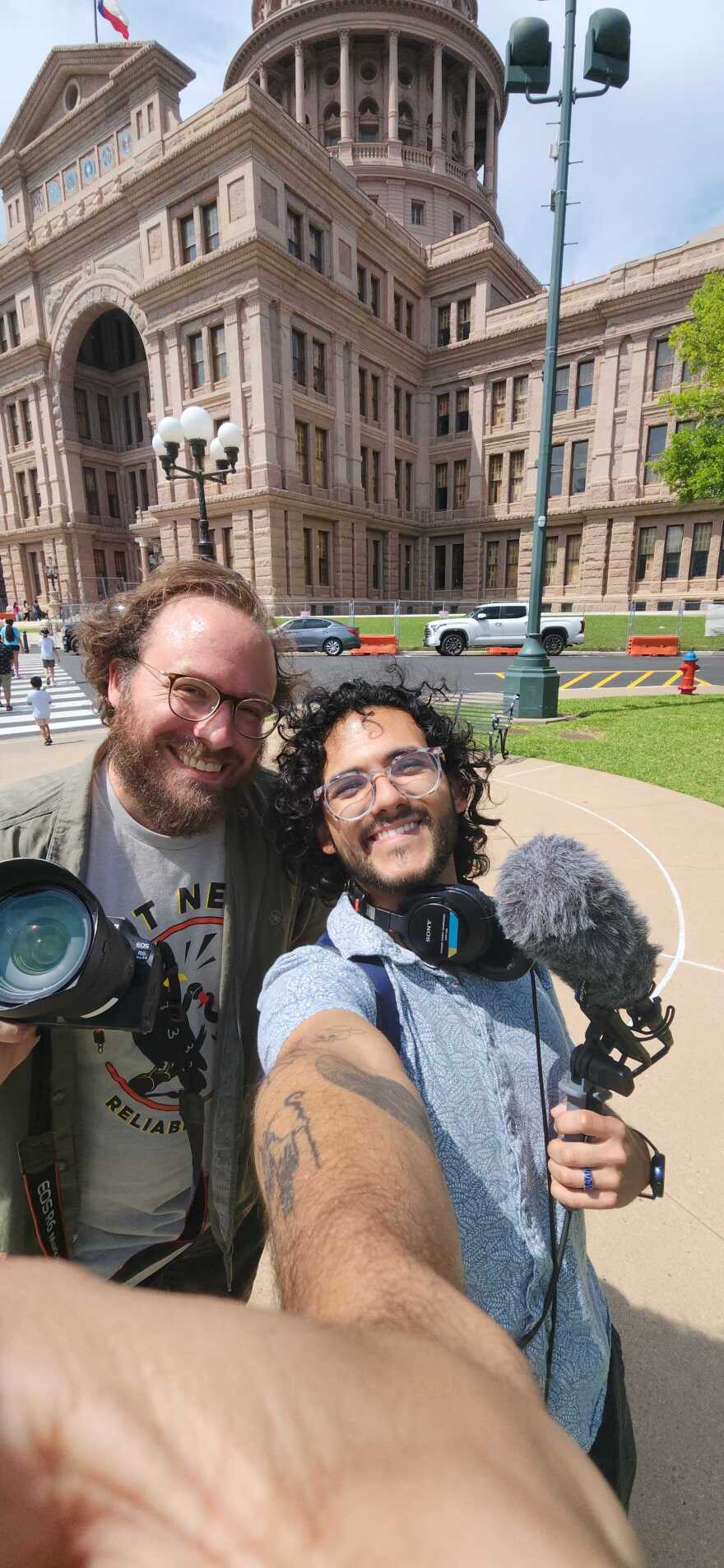 KUT Photographer Michael Minasi and KUT Producer Juan Garcia pose for a selfie outside the Texas Capitol.