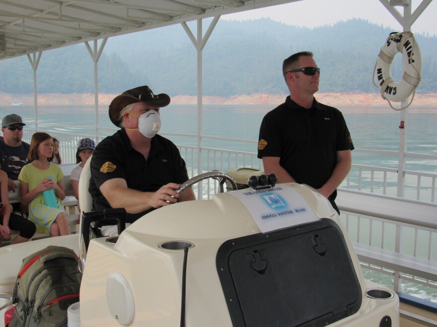 Matthew Doyle, general manager at Shasta Caverns, and Tim Lehman, captain of the Cavern Princess tour boat, ride across Lake Shasta with a group of tourists on Aug, 17. The business is one of many which suffered loss of business from wildfire smoke.