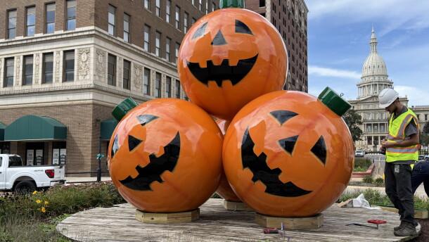 Large jack-o-lantern ornaments sit in front of the Michigan State Capitol