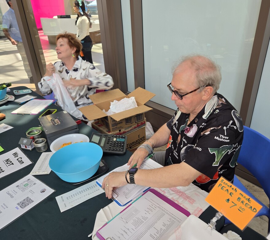 Sanda Coyle and Robin Whitson help check out customers at the farmer's market on May 12, 2026