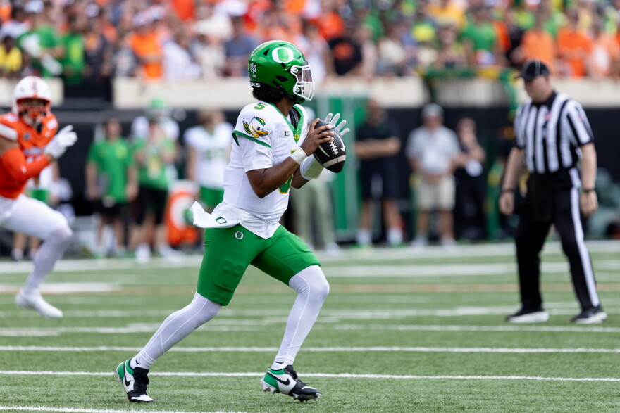 Oregon quarterback Dante Moore prepares to throw a football field.