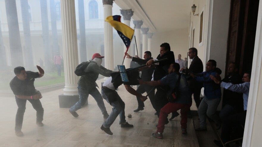 Opposition lawmakers brawl with pro-government militias trying to force their way into the National Assembly in Caracas on Wednesday.