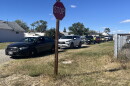 A line of cars waiting to receive food in Rock River. A stop sign in the foreground.