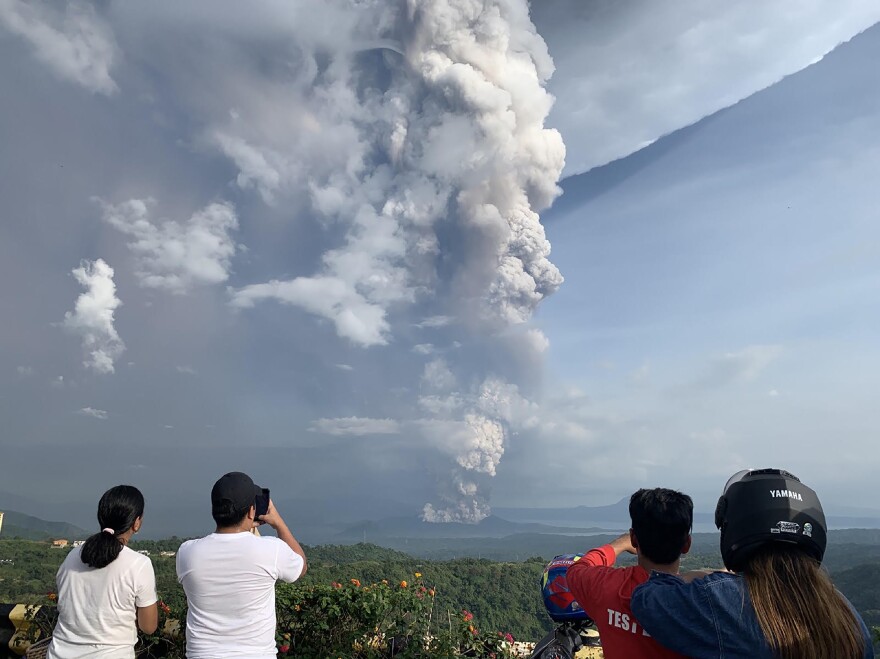 People take photos of the Taal Volcano from the vantage point of the town of Tagaytay in Cavite Province, southwest of Manila on Sunday.