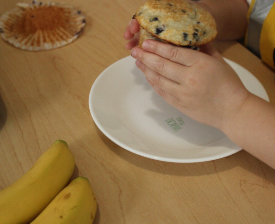 A child at Just Like Mine Daycare in Lincoln, Nebraska, eats a blueberry muffin for breakfast on July 22, 2026.
