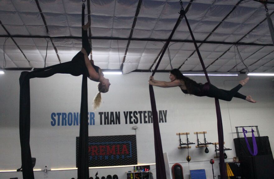 Jenna Algeo and Terri Davenport practice poses on the silks at Fit to Fly