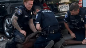 Several police officers hold down Kareem Franklin, 23, during his arrest on Monday, June 8.