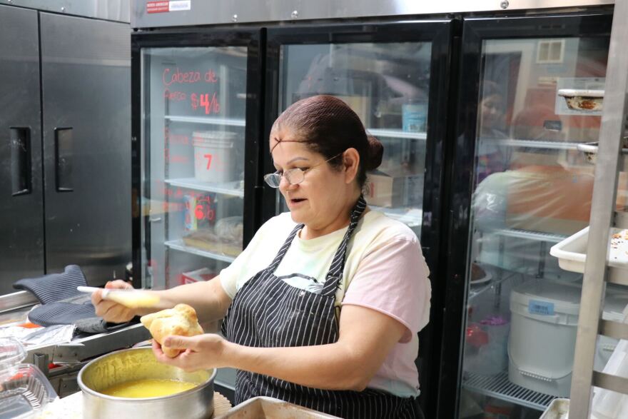 Socorro Gonzalez adds butter to a finished Pan de Muerto at La Mexicana bakery in Nashua on Wednesday, Oct. 30, 2024.