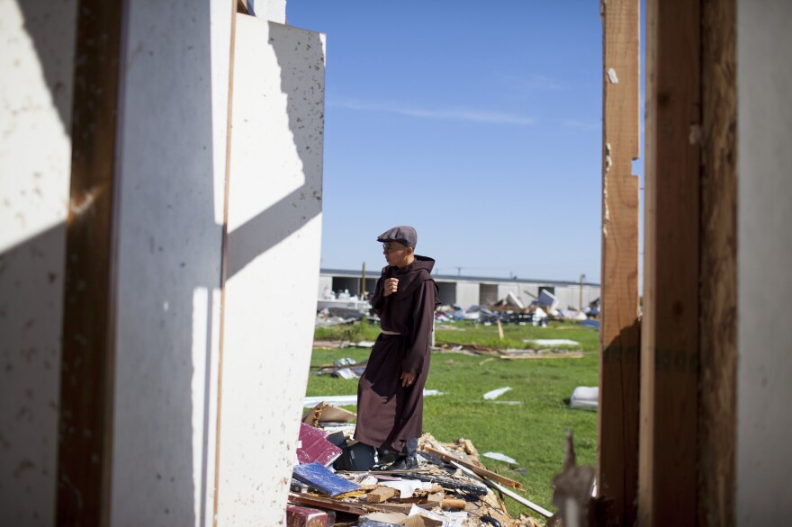 Father John Tran looks through what is left of his rectory next to St. Peter Catholic Church. "My biggest concern is how to rebuild the church for the people," Tran says. "They have lost a lot and are disappointed. It is hard to accept."