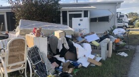 Waterlogged storm debris lines the streets of the Palm River trailer park, where many residents lost nearly everything they owned. One resident told WLRN she and her husband are sleeping in their car outside their trailer because they don't want to leave what few belongings they have left.