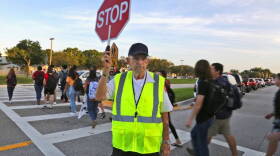 Crossing guard Tony Sorrentino helps Marjory Stoneman Douglas High School students return Wednesday for the first day of school. The next day, a student pulled the fire alarm. 