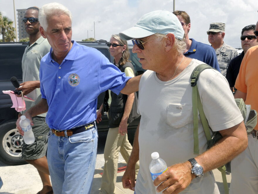 Florida Gov. Charlie Crist (left) and entertainer Jimmy Buffett walk along Pensacola Beach, where Buffett plans to open a new hotel.
