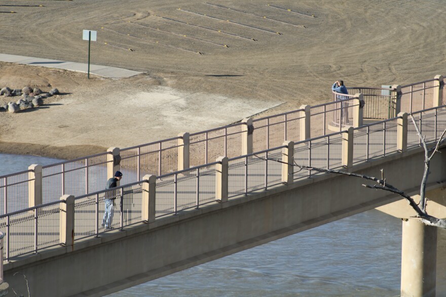 Pedestrians walk across a bridge spanning the Colorado River in Grand Junction, Colo. on Jan. 25, 2024. The Colorado River District says buying the Shoshone water right will bring more predictable flows to the river's '15 mile reach.'