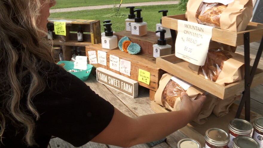 A woman restocks her farm stand with more bread.