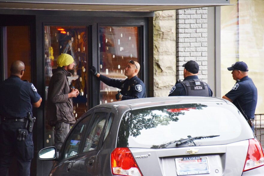 Seattle Police Officer Louis Chan, center, talks with a man in Ballard about his erratic and threatening behavior. Chan is partnered with a social worker to help deescalate volatile situations.