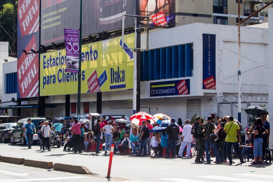 Venezuelans line up outside a branch of an electronics store in Caracas on Nov. 11. President Maduro ordered electronics stores to lower their prices as a measure against inflation, causing masses of people to queue outside stores in hopes of grabbing bargains.