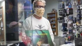 Art Sutch talks to customers during one of his last days operating a brick and mortar camera shop in Juneau on Saturday, April in Juneau. After 25 years in downtown, Sutch is closing his store. He said the COVID-19 pandemic is partially to blame. (Photo by Rashah McChesney/KTOO)