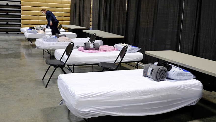 Brett Peppin, director of environmental health with Boone County Health Department, looks at the items on a bed in a building at the Boone County 4-H Fairgrounds, Monday, April 6, 2020, in Lebanon, Ind. The building was prepared to handle 75 COVID-19 patients. The new coronavirus causes mild or moderate symptoms for most people, but for some, especially older adults and people with existing health problems, it can cause more severe illness or death.