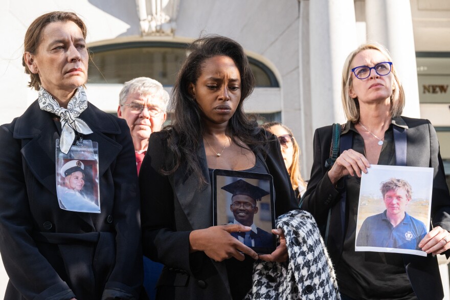 Catherine Berthet (left), Zipporah Kuria (center) and Naoise Connolly Ryan (right) hold photos of relatives who were killed in the crash of Ethiopian Airlines Flight 302 in 2019.