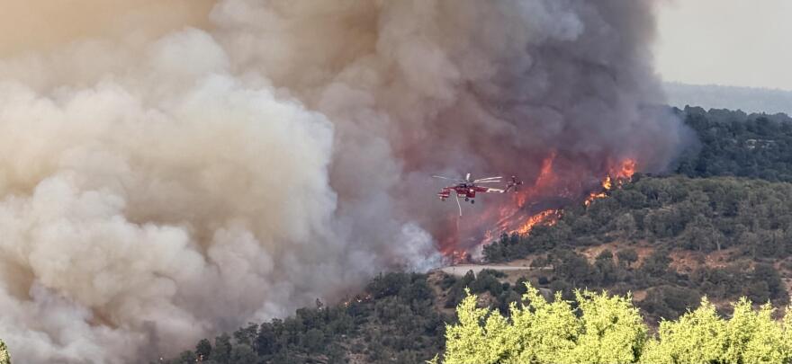A helicopter hovers near the Ferris Fire