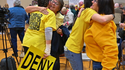 Members of the Archbald community hug each other after borough council denied a data center campus developer's zoning application.